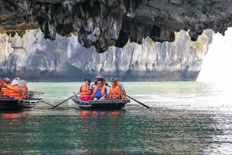 Bamboo Boat Ride Luon Cave Halong Bay tourists inside cave Tourists on a bamboo boat exploring inside the limestone cave at Luon Cave, Halong Bay, surrounded by stalactites