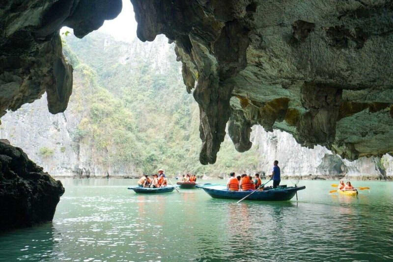 Bamboo Boat Ride Luon Cave Halong Bay silhouette in cave Silhouetted bamboo boat with tourists paddled through the cave opening in Luon Cave, Halong Bay
