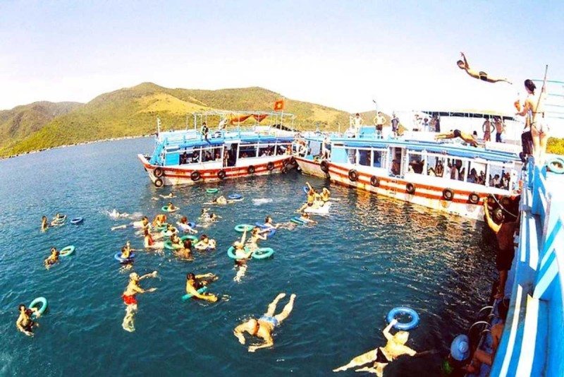 Boat Cruise Hon Mot Island with Swimmers and Boats People swimming and enjoying the boat cruise at Hon Mot Island Nha Trang with two boats in the background