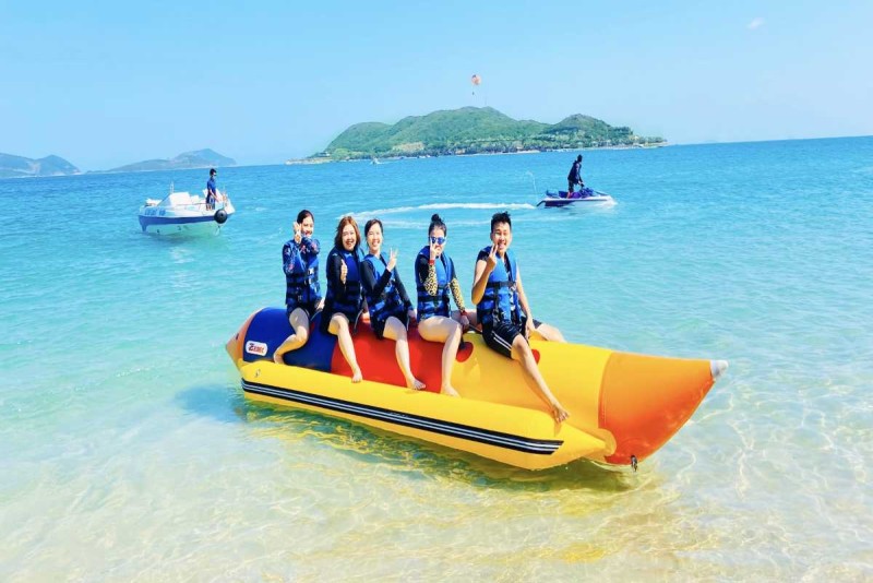 Busy Boat Cruise and Swimming Area at Hon Mot Island Nha Trang Multiple boats and tourists swimming and enjoying water activities near Hon Mot Island, Nha Trang