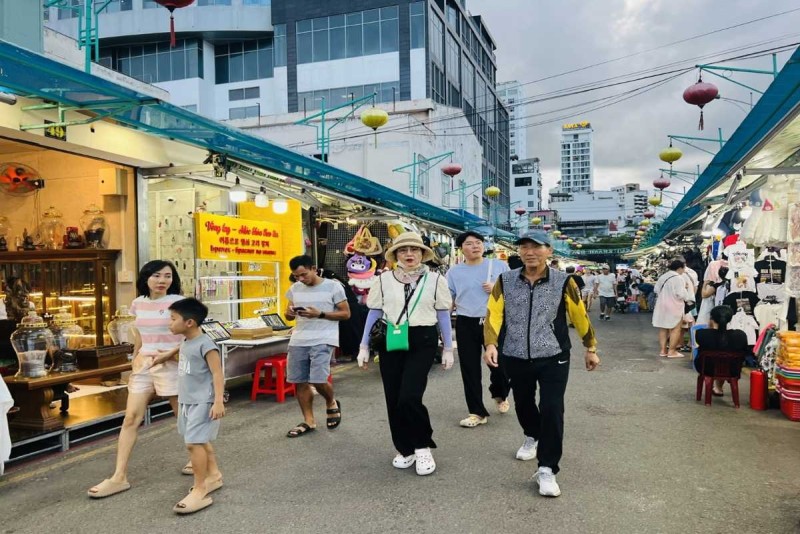Busy Evening Scene at Dam Market Nha Trang Evening shoppers walk through bustling Dam Market Nha Trang filled with market stalls