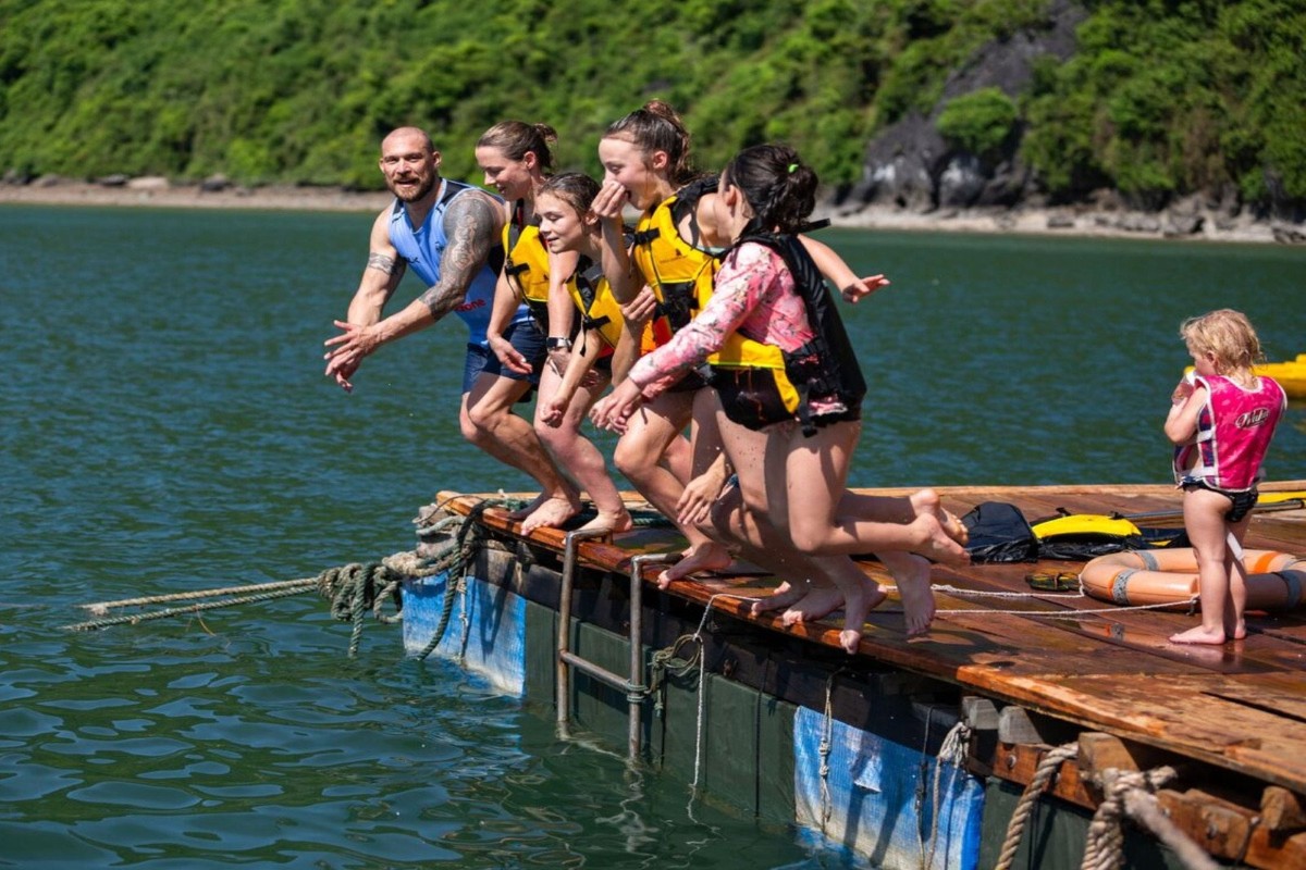 A group of friends swimming together in Halong Bay’s calm, picturesque waters.