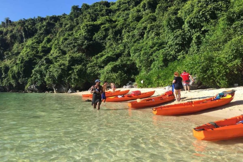 Kayaking Cong Do Island Bai Tu Long Bay calm water paddling Kayaking Cong Do Island Bai Tu Long Bay shows two paddlers navigating calm, emerald waters surrounded by lush karst islands.