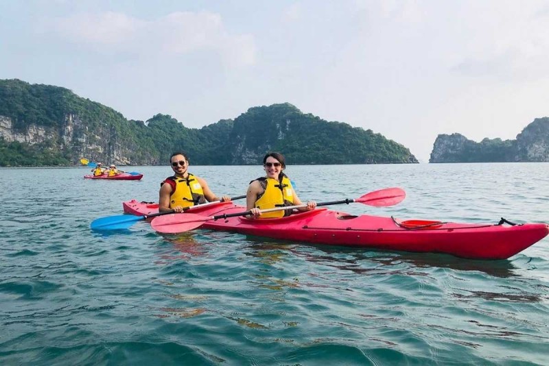 Kayaking Cong Do Island Bai Tu Long Bay morning paddling group Kayaking Cong Do Island Bai Tu Long Bay features a group of kayakers paddling early morning on calm emerald waters among limestone islands.
