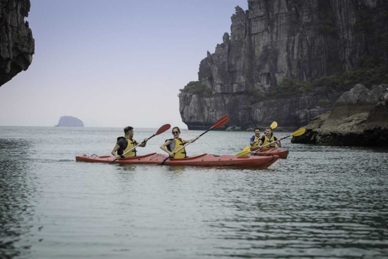 Kayaking Cong Do Island Bai Tu Long Bay vibrant scenery Kayaking Cong Do Island Bai Tu Long Bay displays kayakers surrounded by lush green islands and vibrant natural beauty.