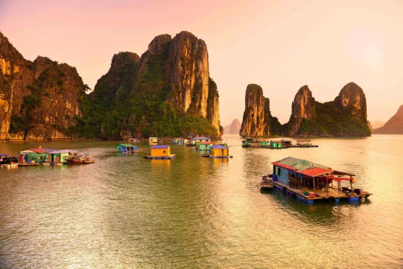 Kayaking Cua Van Halong Bay at golden hour scenic karsts view Kayaking Cua Van Halong Bay during golden hour with scenic limestone karsts and calm waters surrounding the village