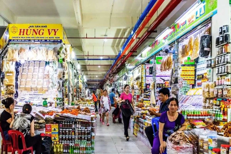 Outdoor Market Section with Colorful Apparel Outdoor clothing and souvenir stalls at Dam Market Nha Trang bustling with shoppers