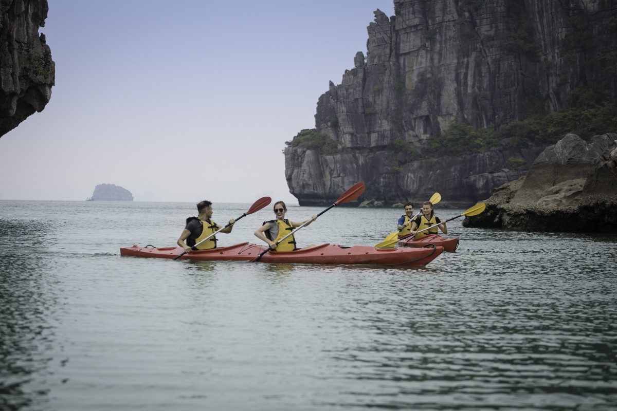 Kayaking in Ha Long Bay with cliffs in the background