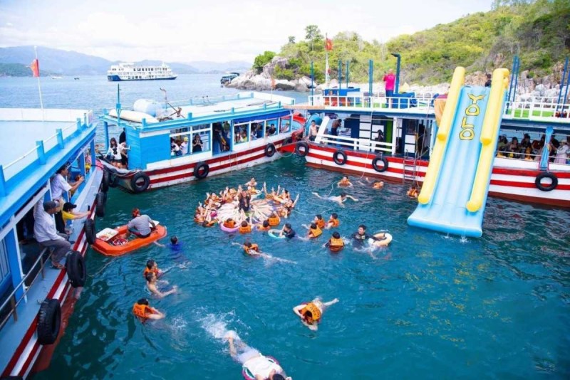 Snorkeling Activities Near Hon Mot Island Nha Trang Tourists snorkeling in clear waters around Hon Mot Island, Nha Trang, observing marine life