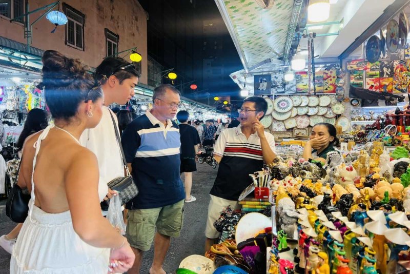 Tourists Exploring Handicraft Stalls at Dam Market Visitors browsing handicraft stalls featuring local souvenirs at Dam Market Nha Trang
