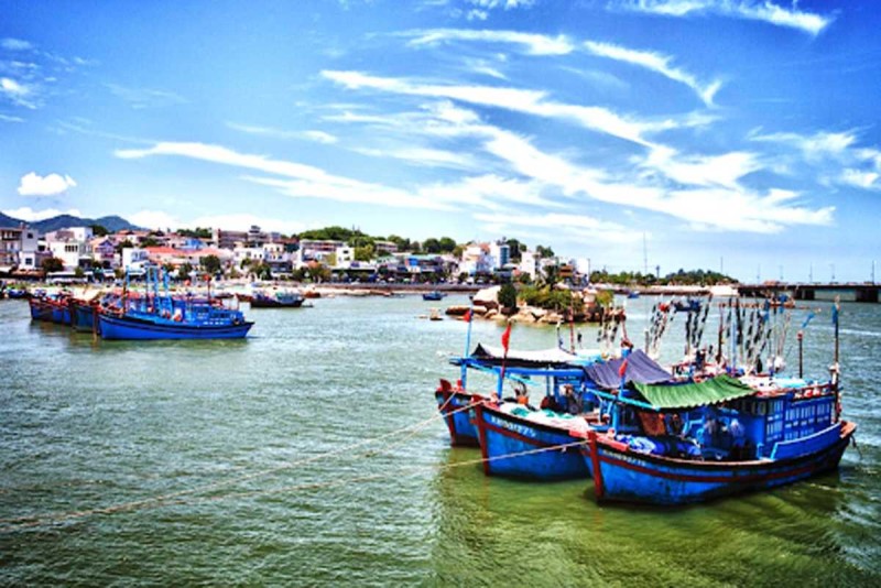 Wide River View with Nha Trang City and Mountains Wide view of Cai River with Nha Trang cityscape and mountain backdrop under partly cloudy sky
