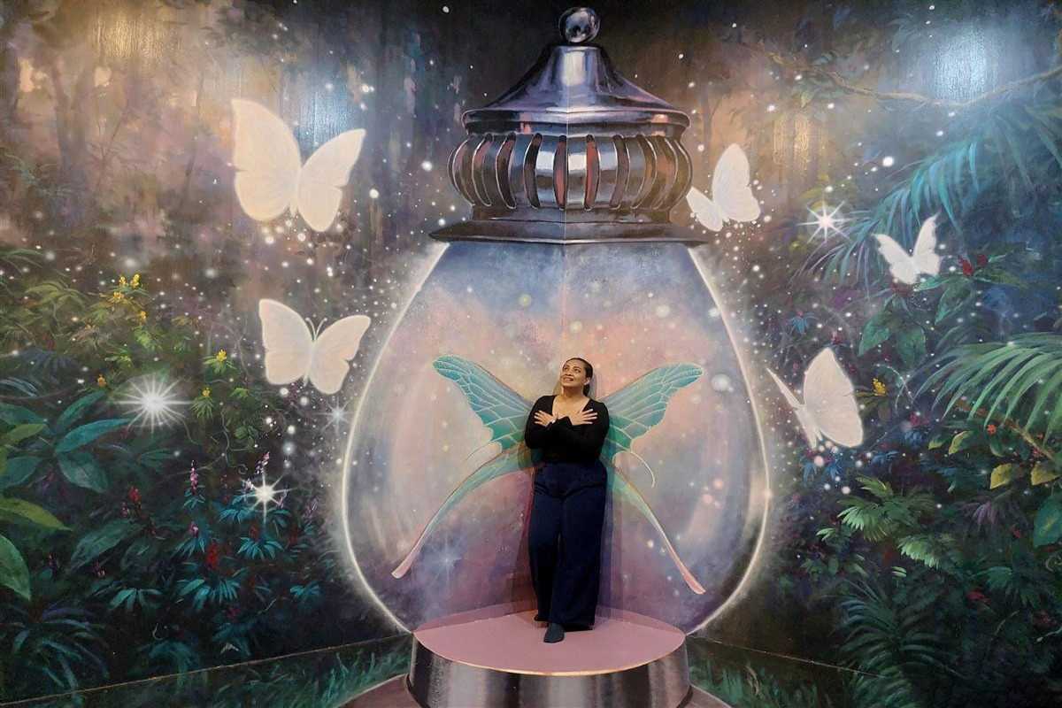 3D Museum Art in Paradise Da Nang magical fairyland butterfly mural 3D Museum Art in Paradise Da Nang displays a fantasy mural with glowing butterflies and a visitor inside a magical lantern for a whimsical effect.