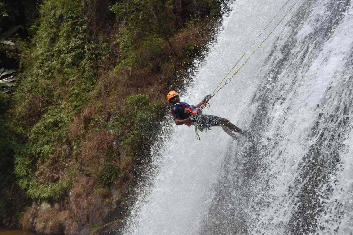 Adventure Canyoning at Datanla Waterfalls in Da Lat Thrill-seeker abseiling down the powerful cascades of Datanla Waterfalls surrounded by lush greenery