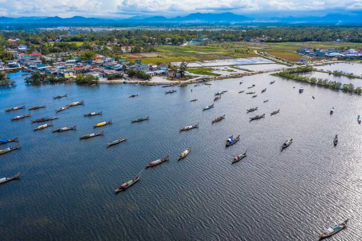 Aerial View of Fishing Boats Navigating Lagoon Paths Birds-eye view of fishing boats navigating narrow water channels between mangroves on Tam Giang Lagoon