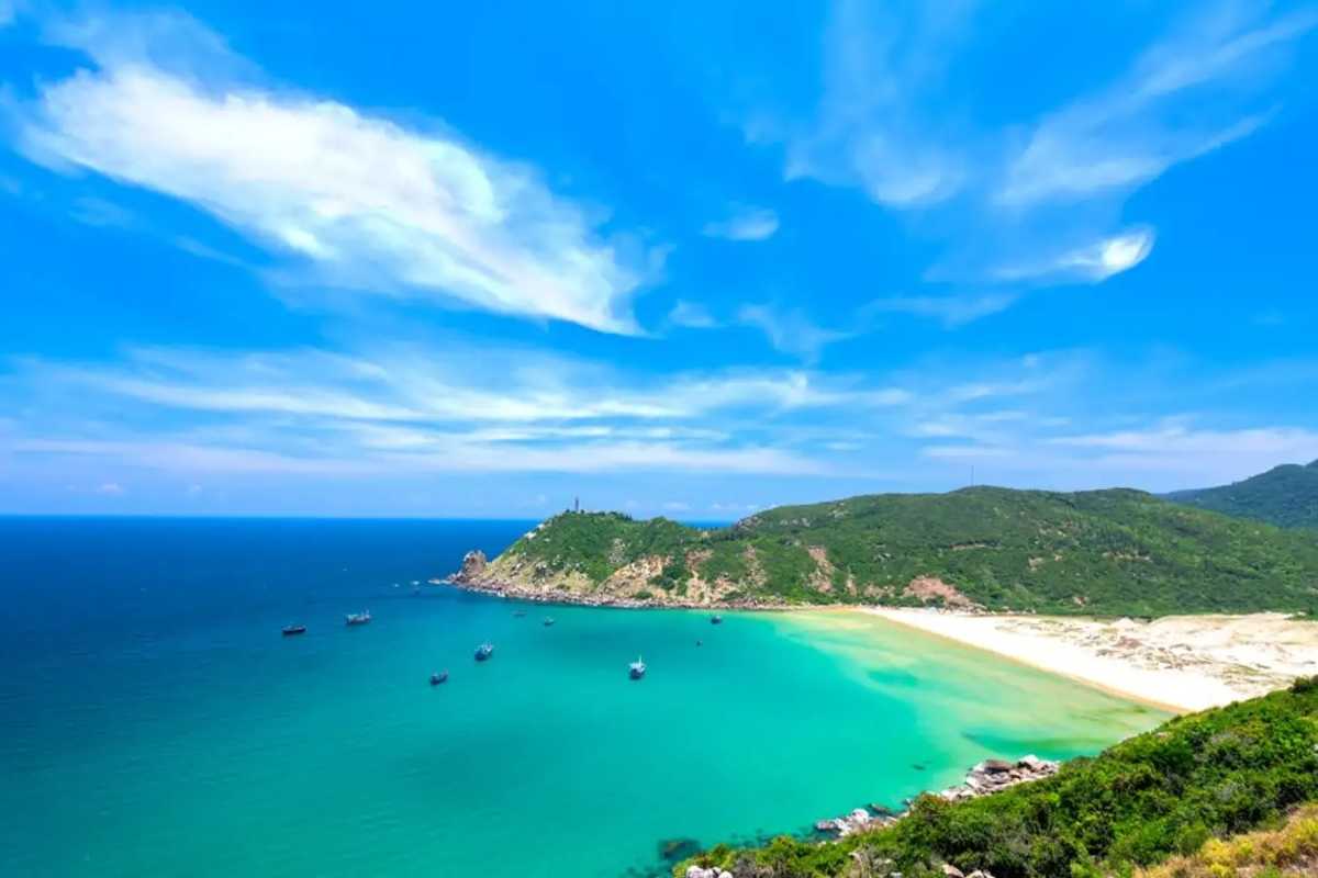Aerial view of rocky coastline and clear waters at Dai Lanh Beach Clear blue waters and rocky coastline with green hills viewed from above at Dai Lanh Beach, Nha Trang