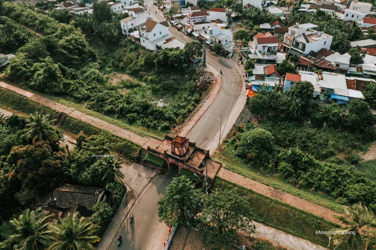 Aerial View of Dien Khanh Citadel Intersection Aerial view of Dien Khanh Citadel showing red-tile gate, curved road, and residential area.
