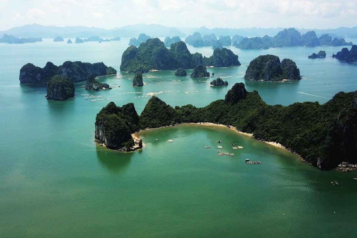 Aerial view of Cong Dam Area in Bai Tu Long Bay, showcasing islands and limestone karsts surrounded by turquoise waters.