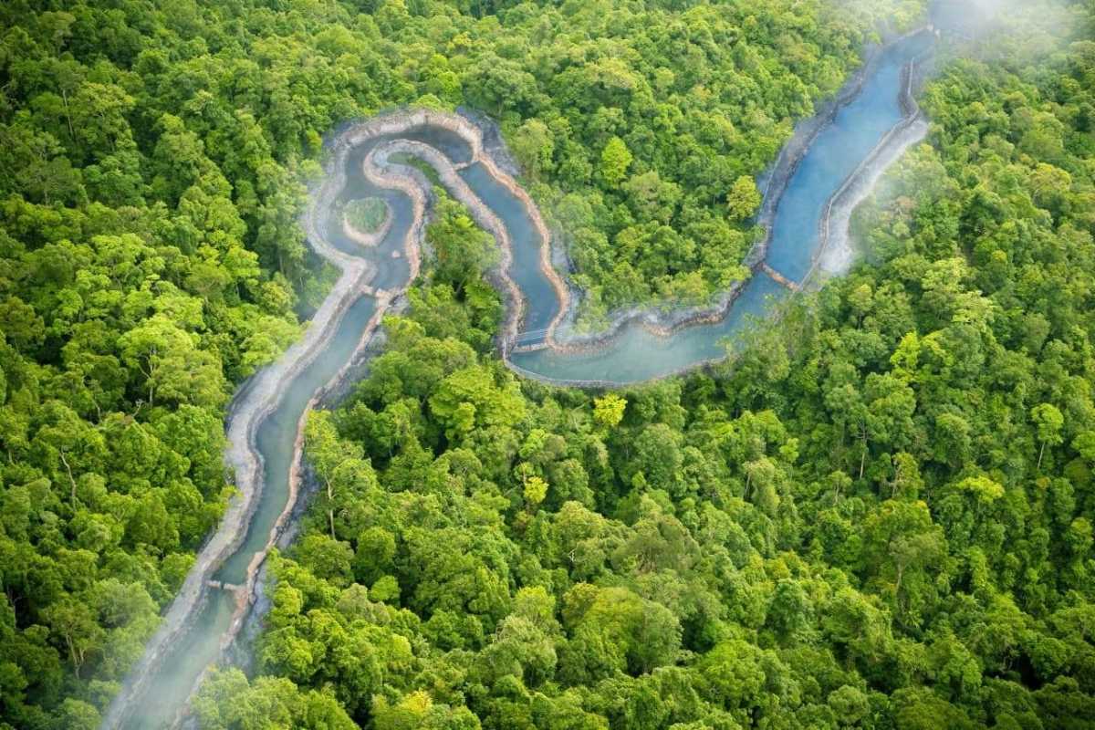 Aerial View of Hot Spring River at Alba Thanh Tan Bird’s-eye view of winding hot spring river surrounded by dense green forest at Alba Thanh Tan