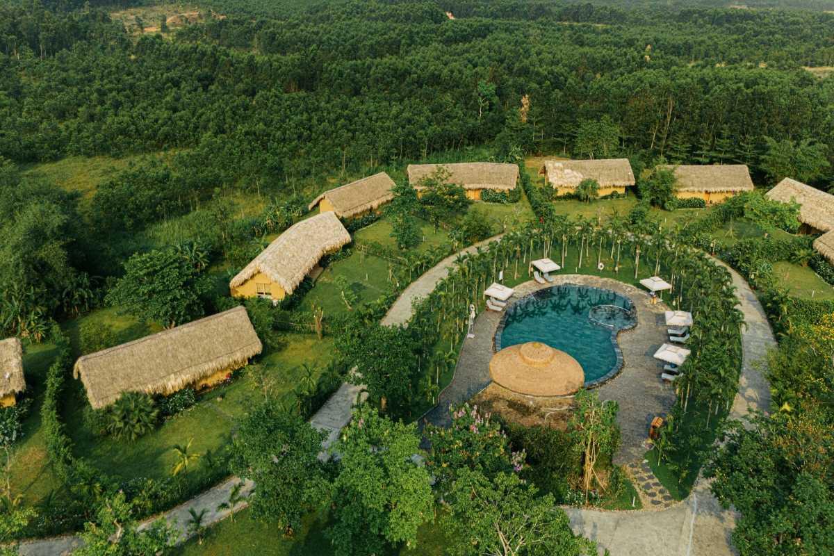 Lush Green Surroundings at Alba Thanh Tan Greenery-filled aerial view of cottages and a large natural pool at Alba Thanh Tan Hot Springs