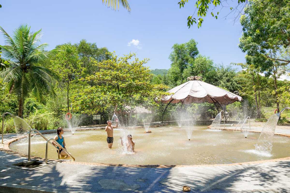 Mineral Water Massage Pool at Alba Thanh Tan Visitors enjoying therapeutic mineral water massage pool surrounded by greenery at Alba Thanh Tan Hot Springs