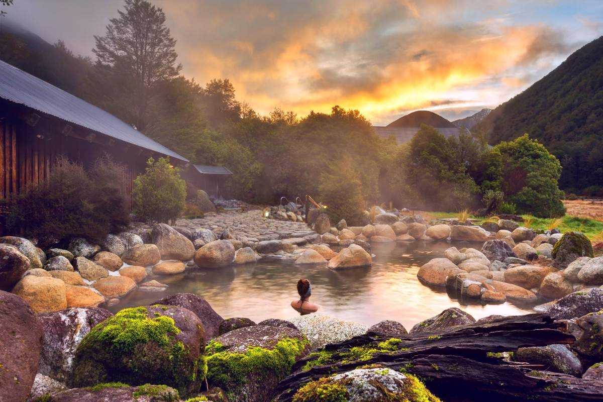 Sunset Soaking at Alba Thanh Tan Hot Springs Woman soaking in stone hot spring pool at sunset with mountains in background at Alba Thanh Tan
