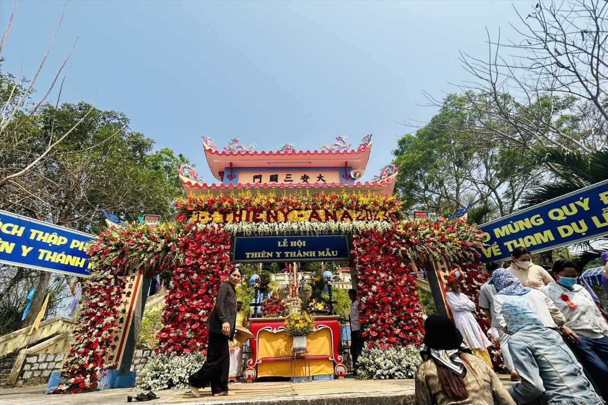 Festival arch with red floral arrangements Festival gate at Am Chua Temple decorated with red flowers during the Thien Y A Na celebration.