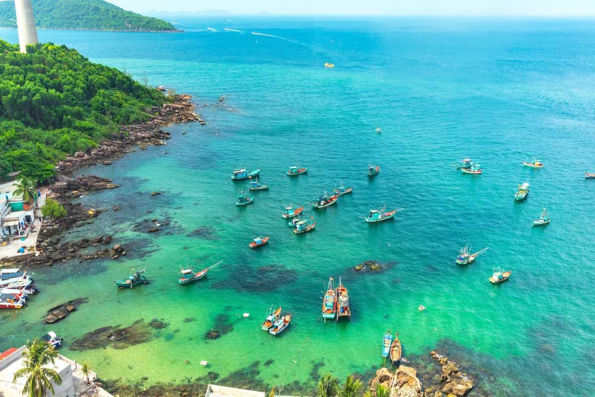 Coastal village and sea in An Thoi Archipelago Coastal village with houses and boats on the shoreline of An Thoi Archipelago