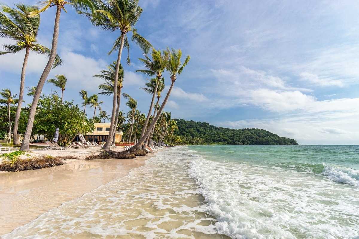 Tranquil beach scene in An Thoi Archipelago Tranquil beach scene with calm waves and palm trees in An Thoi Archipelago