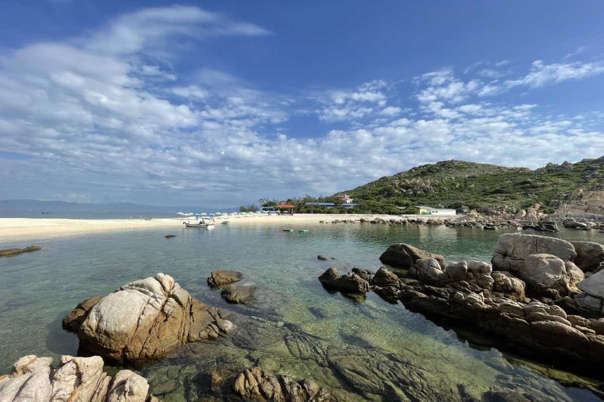 Scenic view of Ancestor Temple of Salanganes on Hon Noi Island surrounded by clear water and rocky coastline