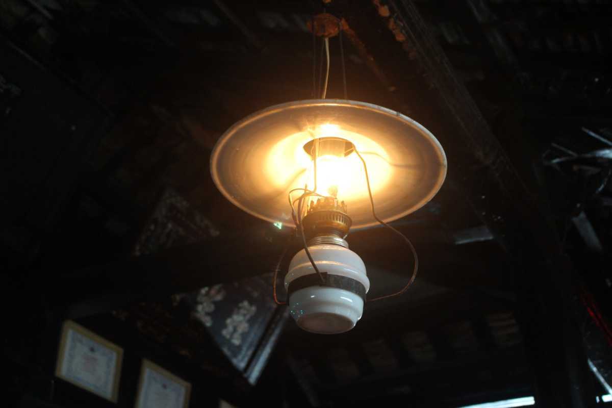 Antique ceiling lamp in Phu Vinh house Close-up of a vintage hanging lamp inside a traditional house at Phu Vinh Ancient Village