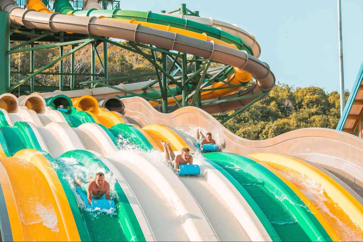 Busy Aquatopia Water Park Pool Area with Slides Visitors enjoying large pool with water slides at Aquatopia Water Park, Hon Thom Island