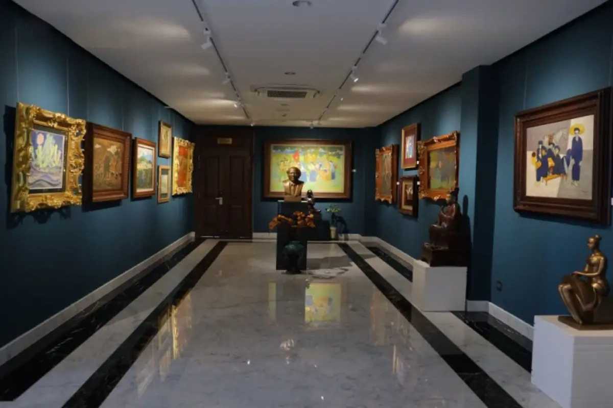Art Enthusiast Viewing Paintings in Museum Art enthusiast closely viewing paintings at Vietnam National Fine Arts Museum