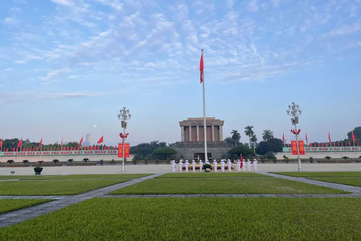 Ba Dinh Square Hanoi - Early Morning Flag Ceremony View Early morning view of the flag raising ceremony at Ba Dinh Square Hanoi, with bright red flags and solemn ceremony proceedings.