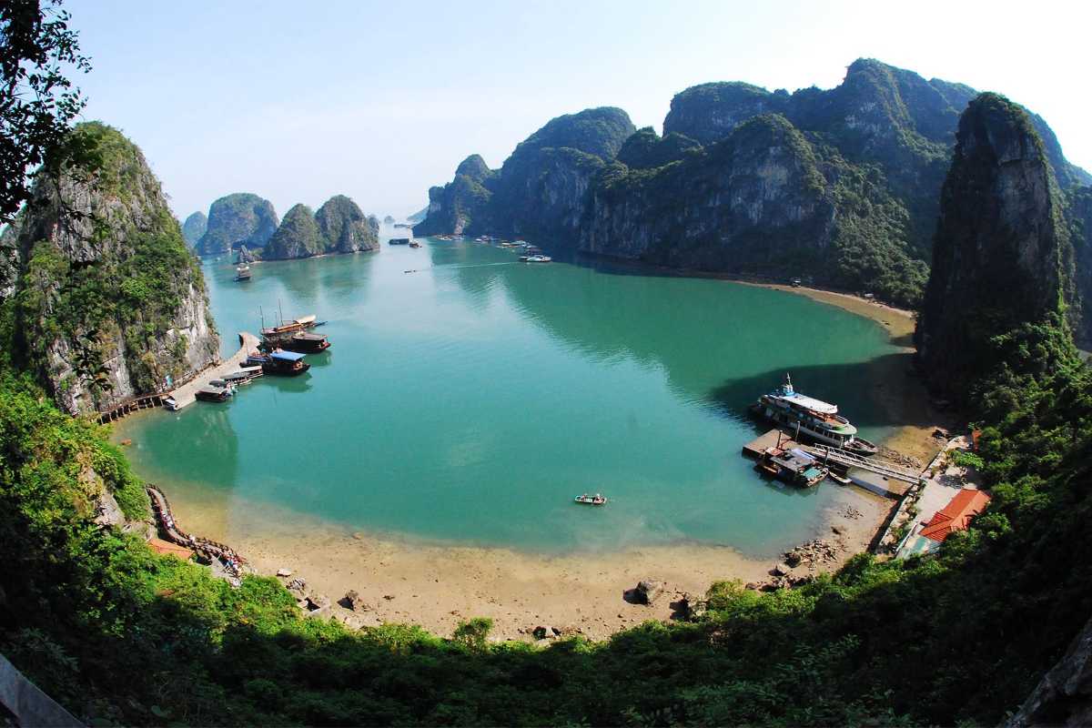 Ba Ham Lake Halong Bay Green Limestone Islands and Docked Boats Green limestone islands at Ba Ham Lake Halong Bay with boats docked at the shoreline
