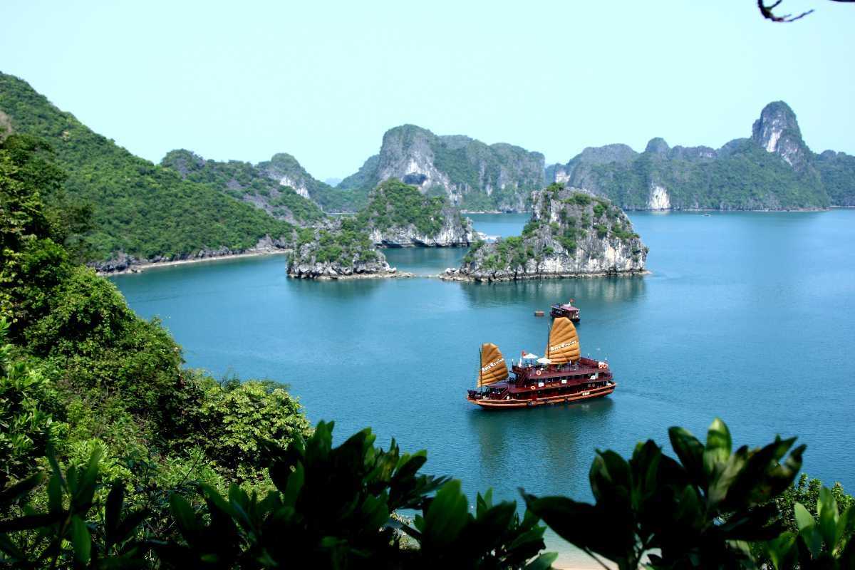 Ba Ham Lake Halong Bay Traditional Wooden Junk Boat in Calm Waters Traditional wooden junk boat cruising the calm waters of Ba Ham Lake Halong Bay surrounded by limestone islands