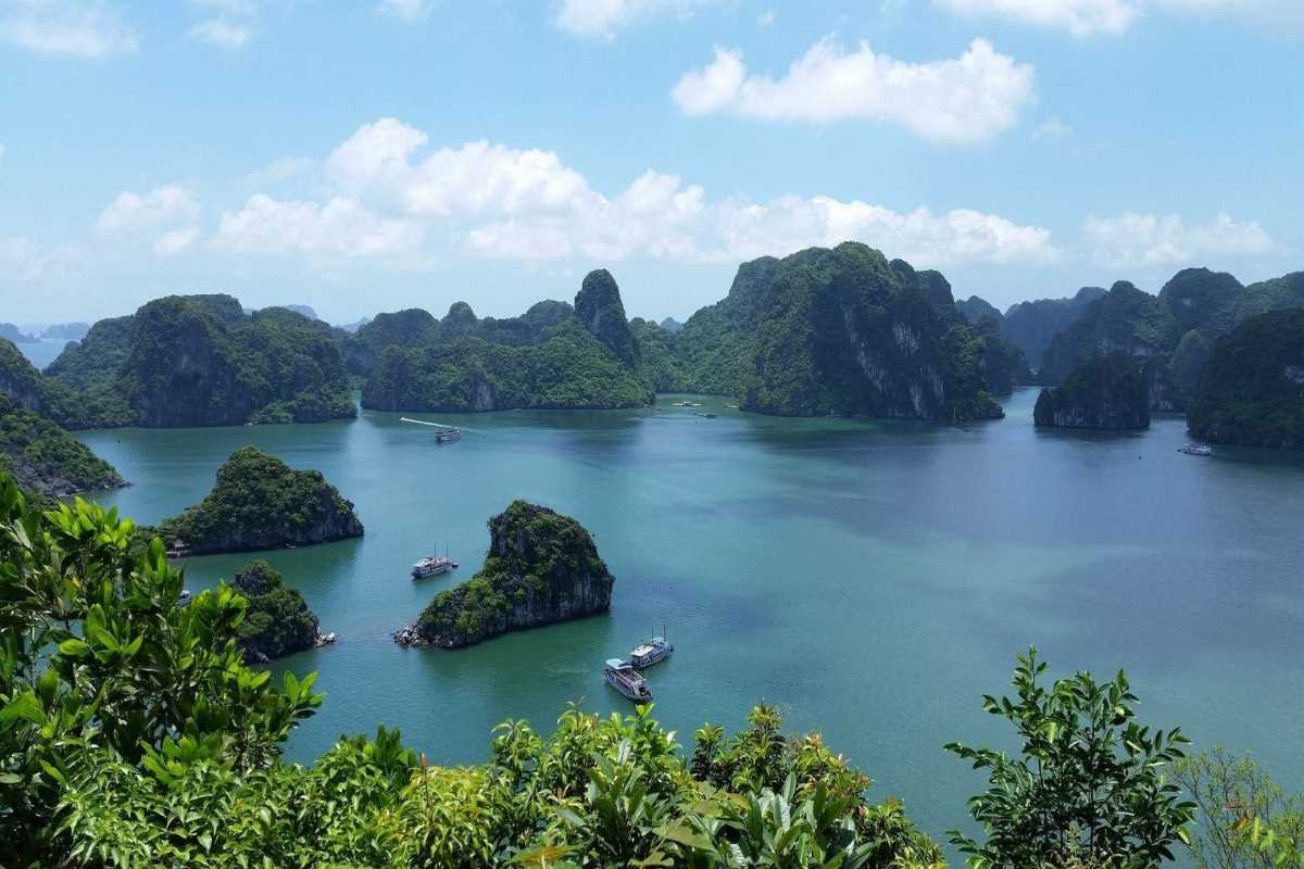 Ba Ham Lake Halong Bay Wide View of Limestone Karsts and Boats Wide-angle view showcasing limestone karsts and boats on Ba Ham Lake Halong Bay’s calm freshwater surface