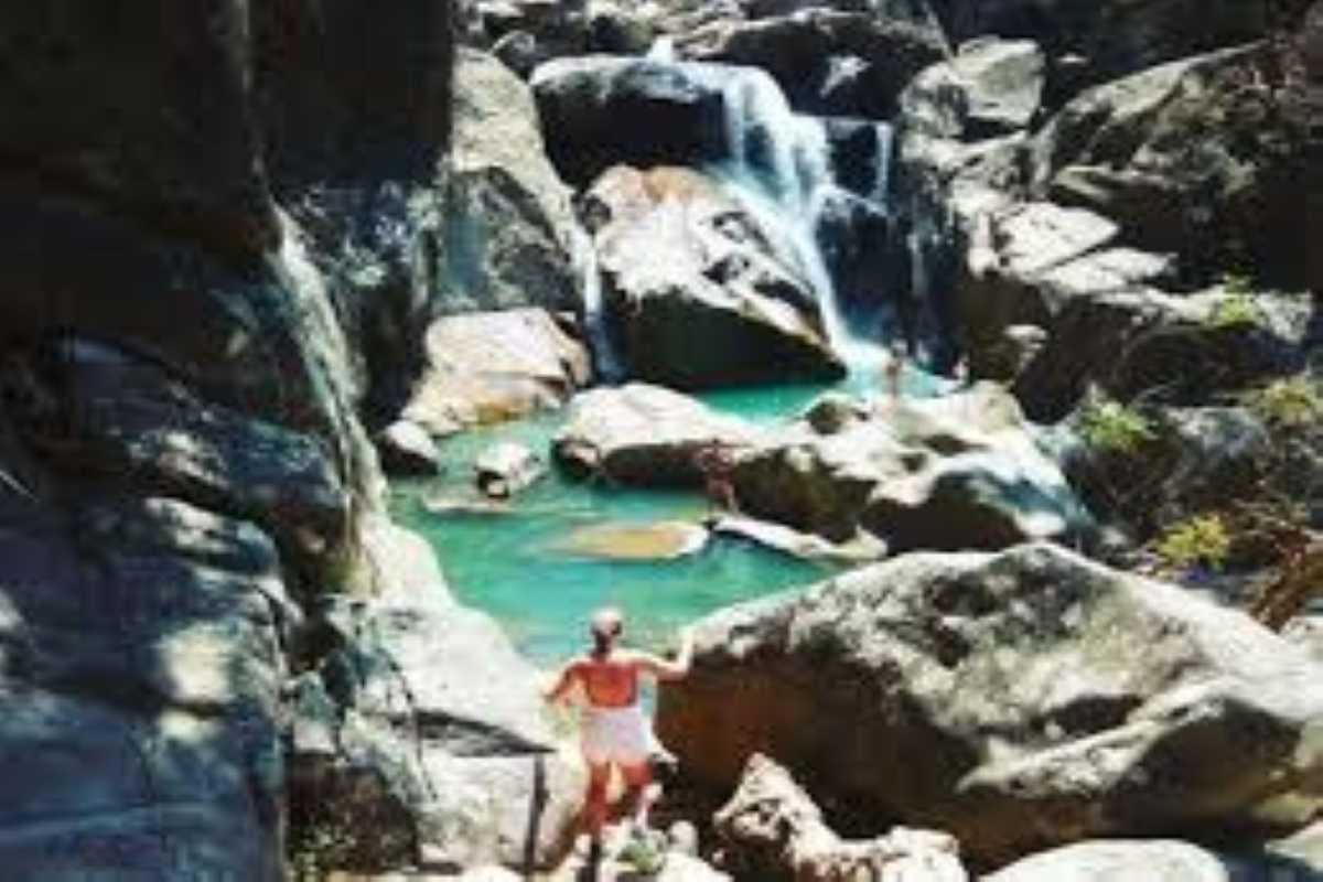 Lower waterfall swimming area Travelers swim in the lower natural pool below a rocky waterfall at Ba Ho in Nha Trang.