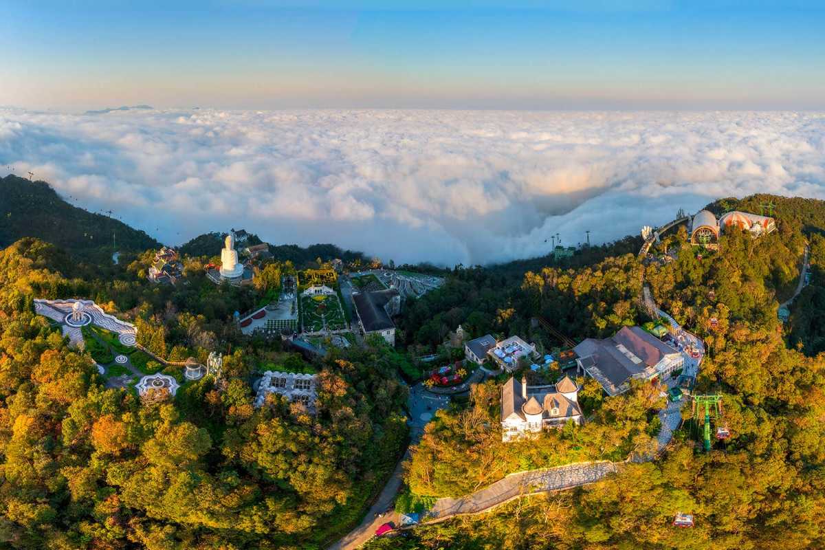 Ba Na Hills Da Nang sunrise panoramic clouds mountain landscape Ba Na Hills Da Nang panoramic sunrise above mountain resort, gardens, pagoda, and thick clouds below horizon