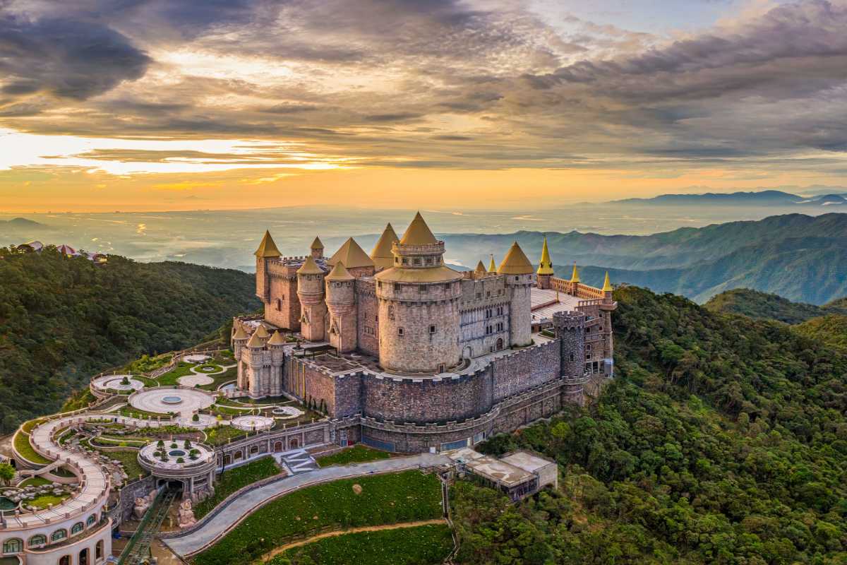 Ba Na Hills French Village castle sunset panoramic mountain view French Village castle at Ba Na Hills during sunset with sweeping mountain views and golden sky