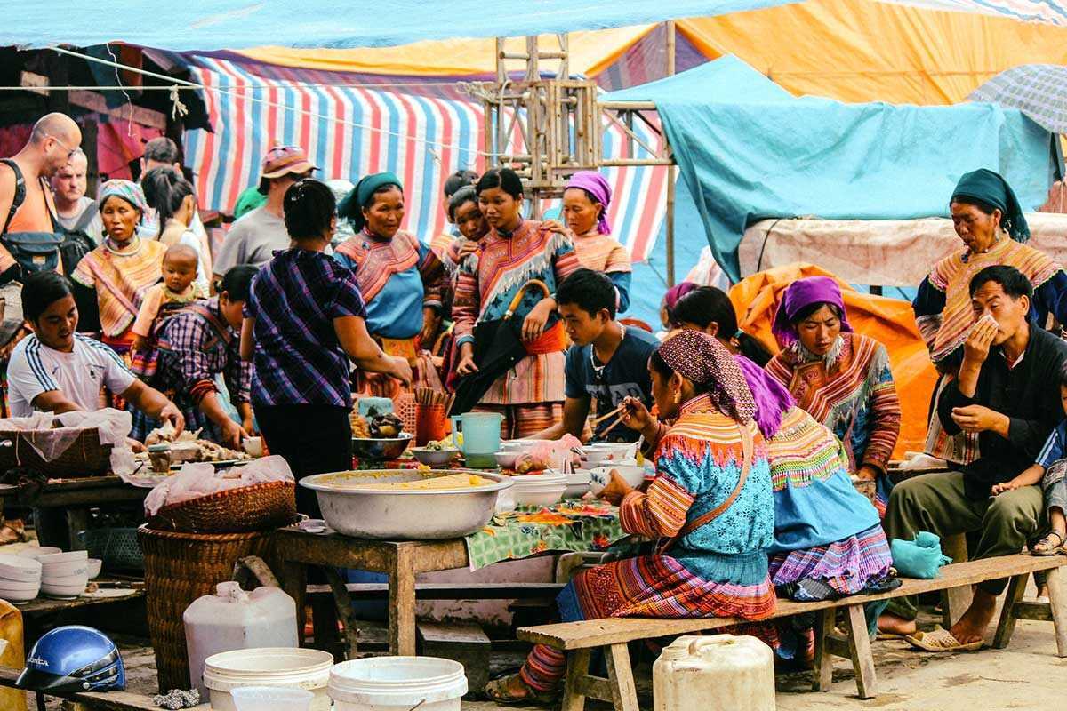 Bac Ha Market Sapa bustling street food and ethnic traders Bac Ha Market street food vendors, ethnic women preparing traditional dishes, and crowds in colorful costumes