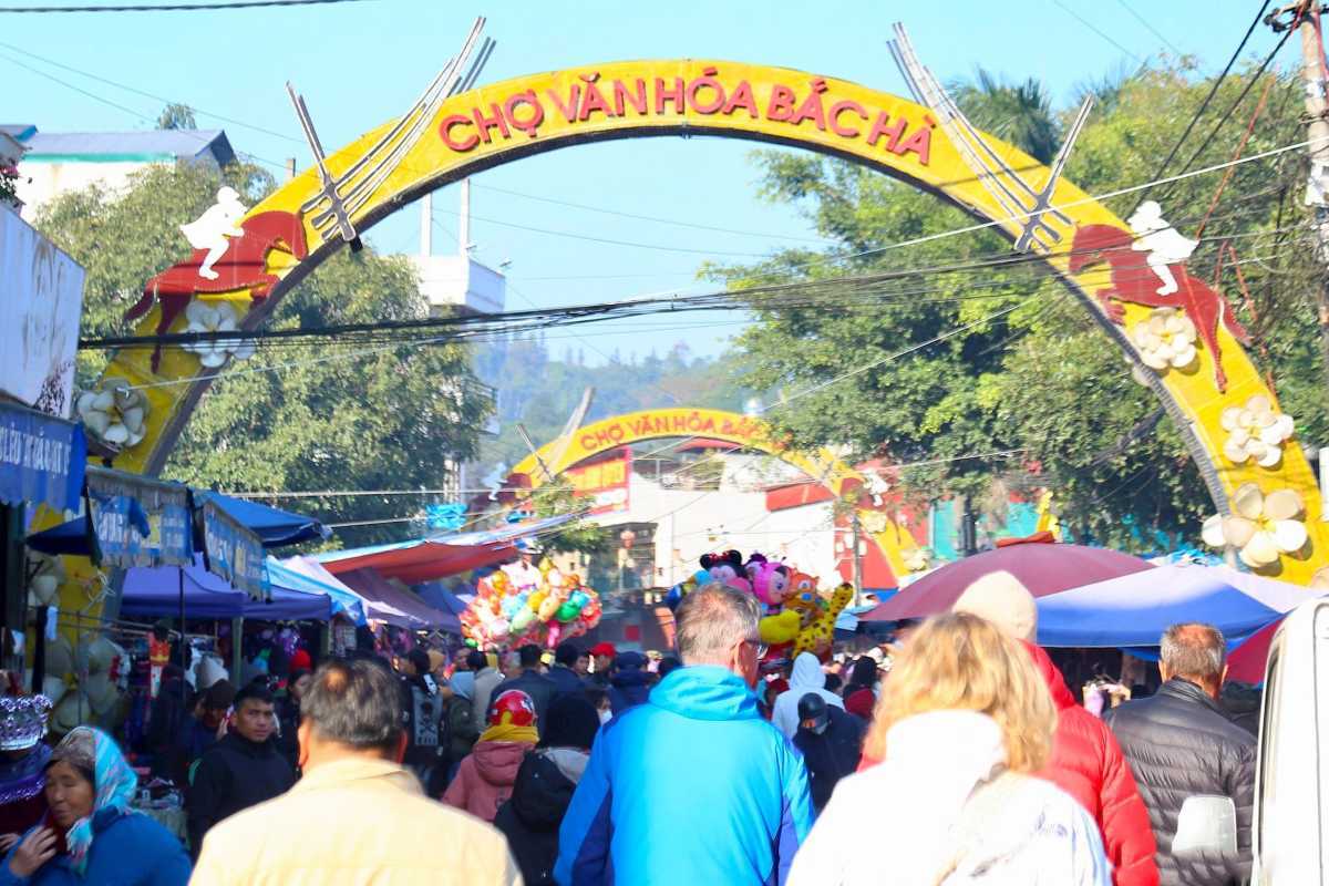 Bac Ha Market Sapa entrance arch and Sunday market visitors Bac Ha Market entrance arch with crowds of local residents and tourists entering the colorful Sunday market