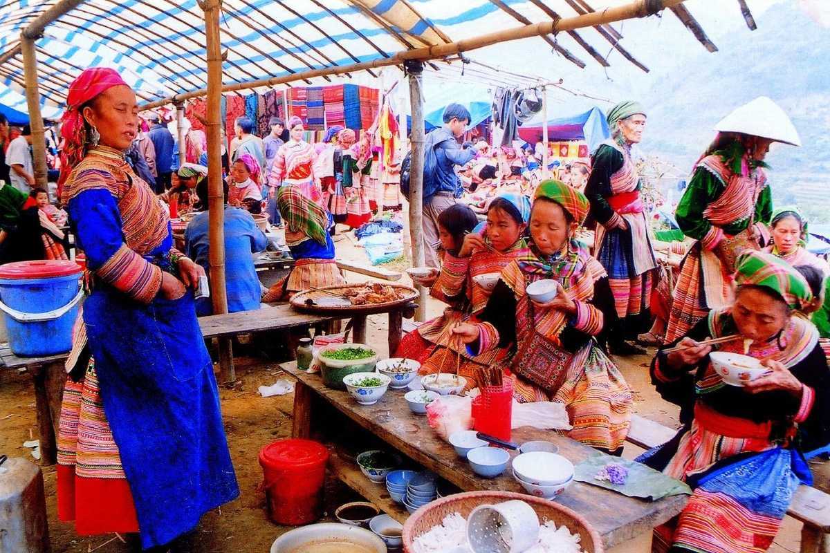 Bac Ha Market Sapa ethnic cuisine and communal dining Bac Ha Market ethnic women in traditional dress enjoying local dishes and communal meals at market food stalls