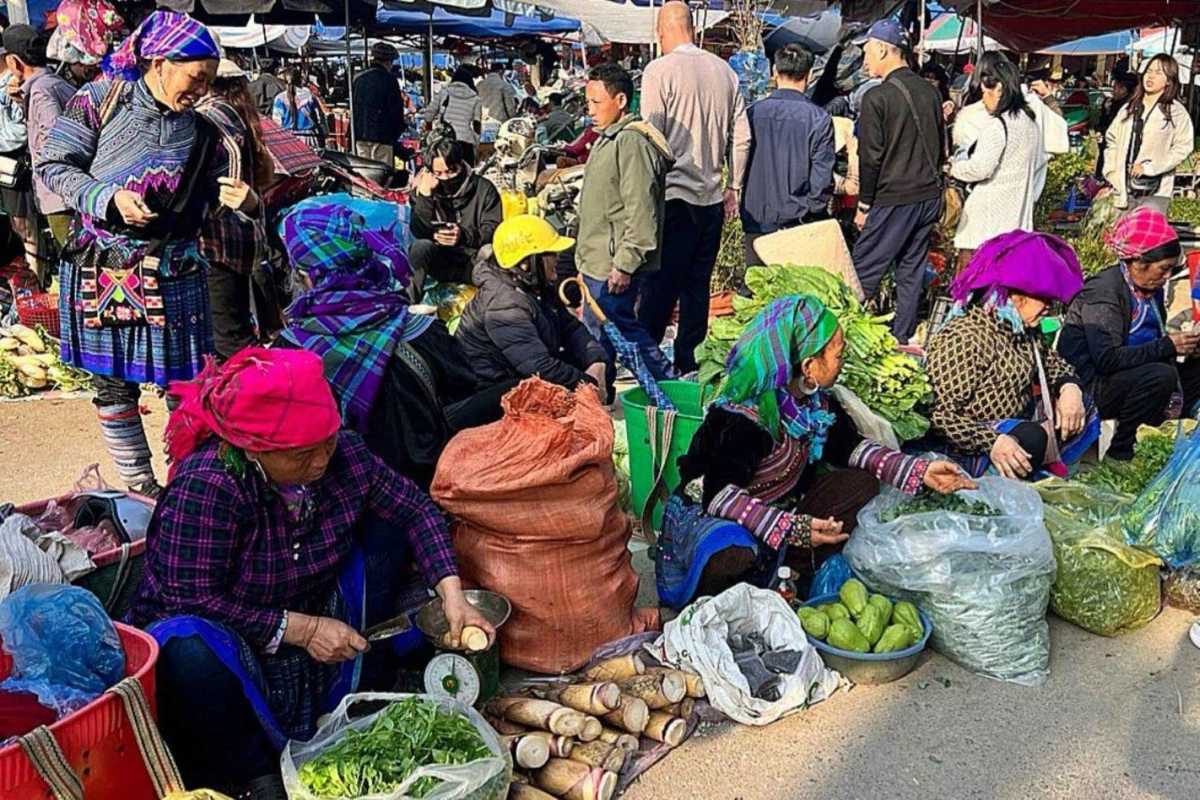 Bac Ha Market Sapa ethnic vegetable vendors and fresh produce stalls Bac Ha Market ethnic women in traditional attire selling vegetables, bamboo shoots, and highland greens in busy market