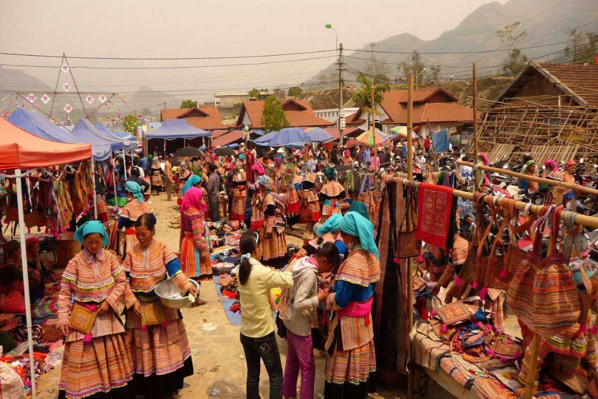 Bac Ha Market Sapa festival crowds and artisan handicrafts Bac Ha Market festival atmosphere with crowds in colorful attire, brocade bags, and handmade crafts at busy stalls