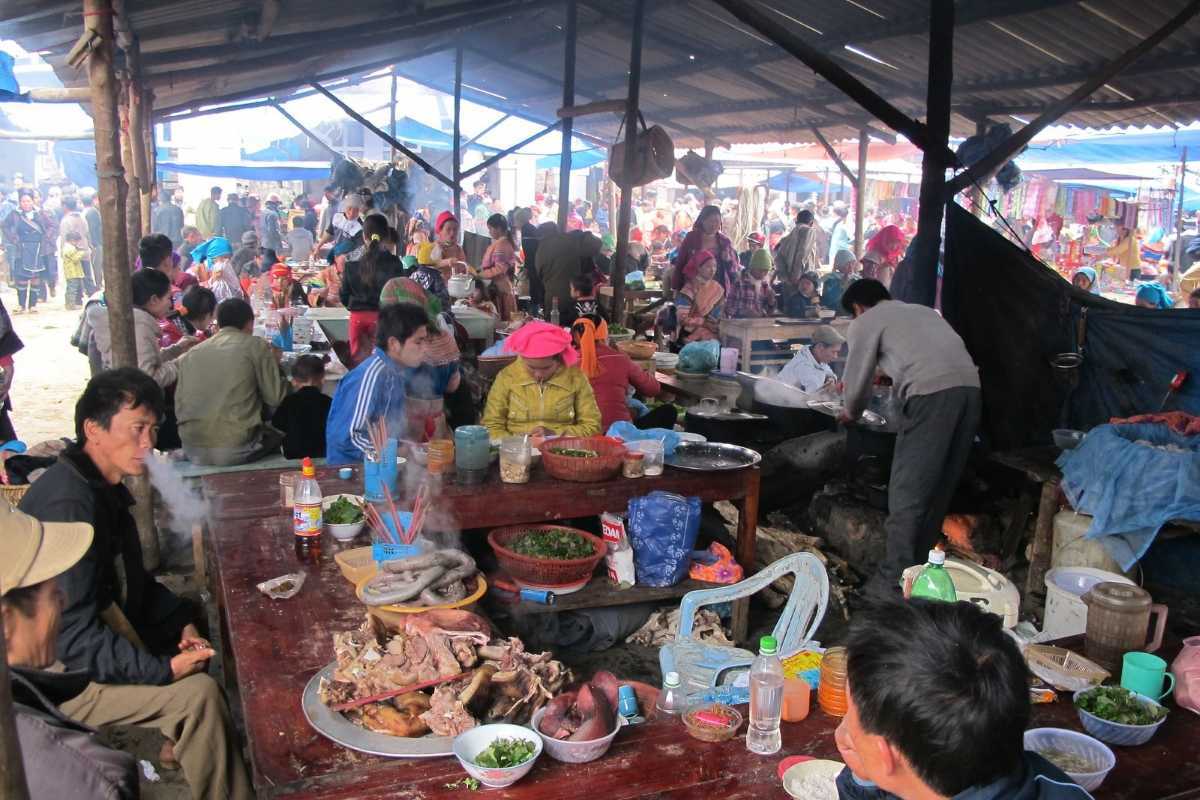 Bac Ha Market Sapa food court and local delicacies Bac Ha Market food court with ethnic locals, traditional dishes, and communal eating in a rustic highland setting