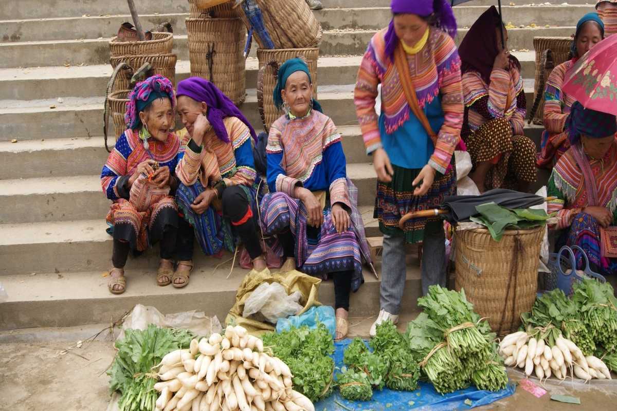 Bac Ha Market Sapa fresh vegetables and highland produce Bac Ha Market ethnic women selling bundles of fresh greens, radishes, and local vegetables on market steps