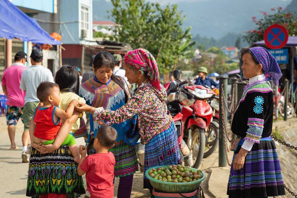 Bac Ha Market Sapa morning market and ethnic families Bac Ha Market bustling morning scene with ethnic families in traditional costumes, fresh fruit baskets, and friendly exchanges