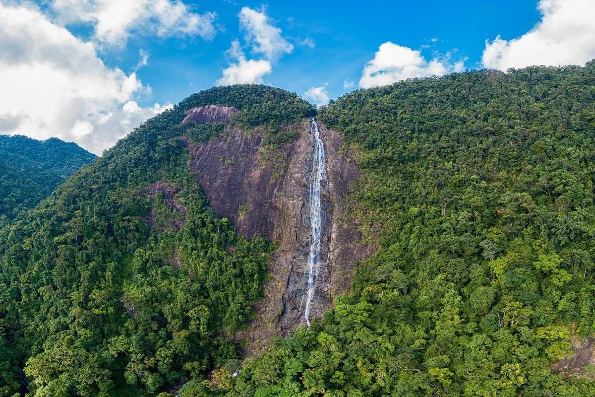 Crystal Clear Waterfall Pool in Lush Bach Ma Forest Natural crystal-clear waterfall pool with rocky banks and vibrant greenery in Bach Ma National Park