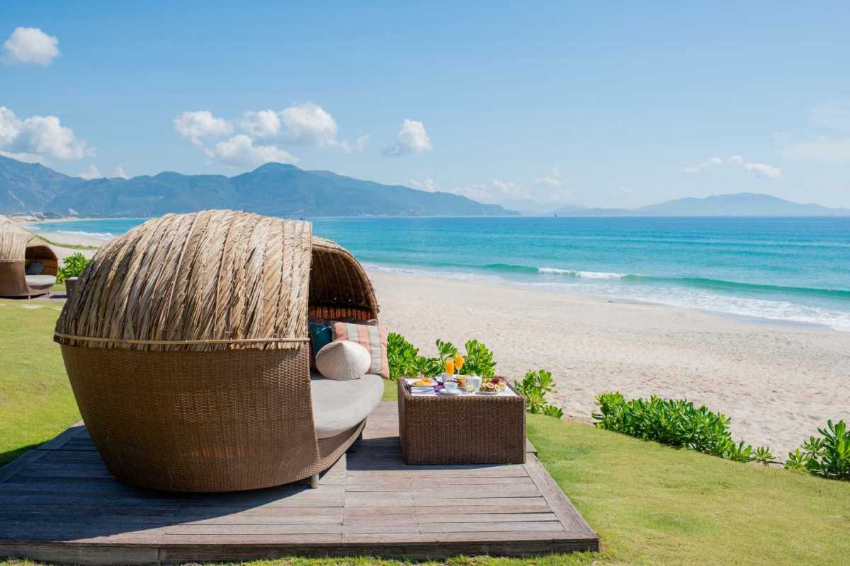Comfortable Beach Seating Area at Bai Dai Beach Nha Trang Comfortable wicker seating and table set by the beach with a picturesque view of Bai Dai Beach Nha Trang.