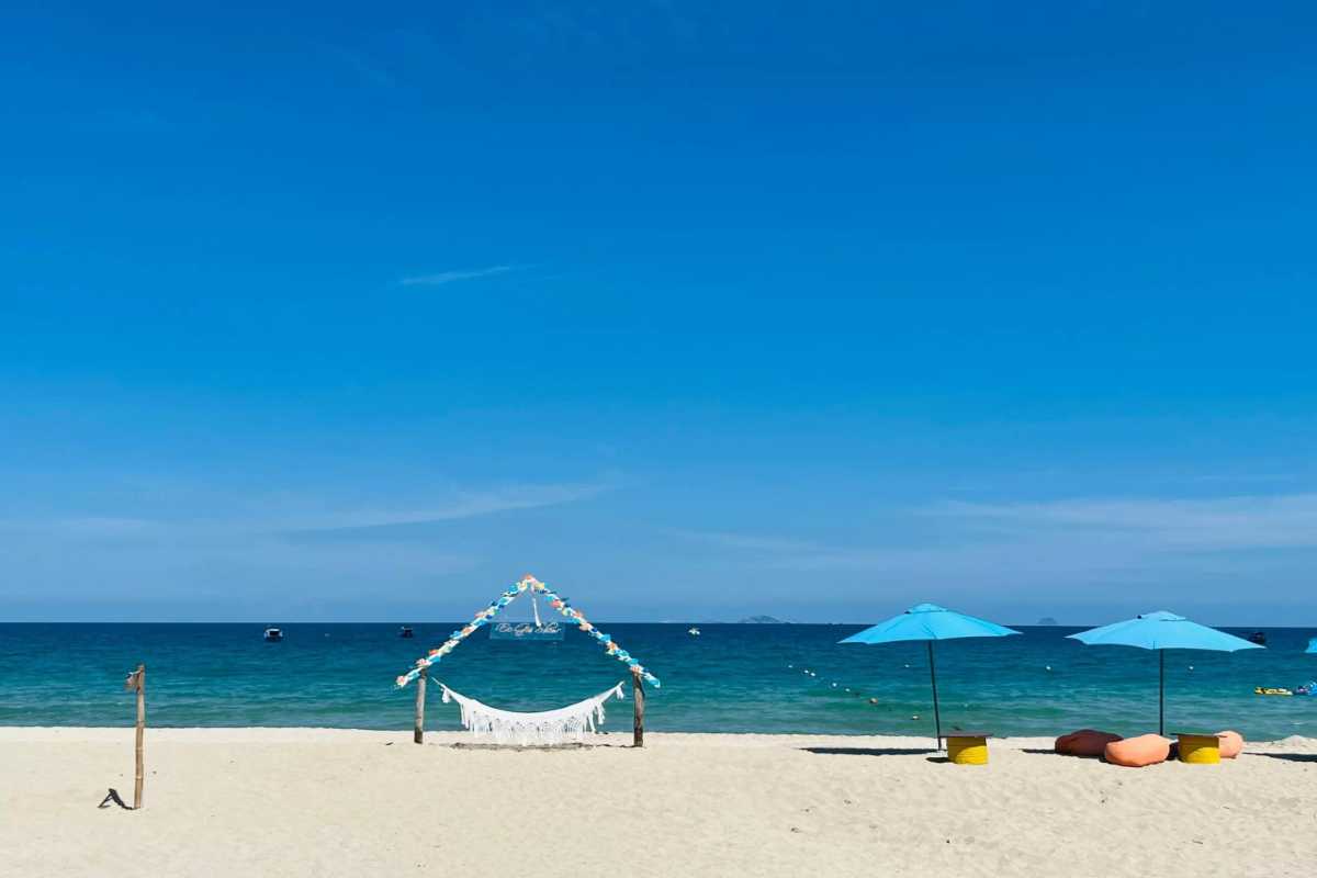 Secluded Beach Cove at Bai Dai Beach Nha Trang A quiet, secluded beach cove with clear blue waters and lush green hills surrounding Bai Dai Beach Nha Trang.